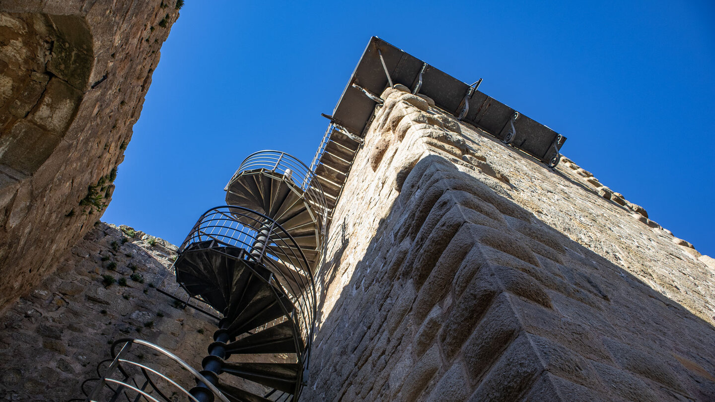 Stahltreppe mit Geländer an der Turmmauer der Burg Hagueneck bei Wettolsheim vor blauem Himmel