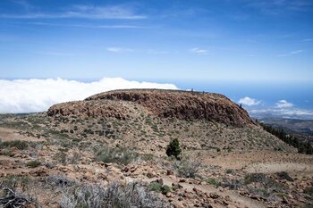 der Sombero de Chasna mit vorgelagertem Felsmassiv – im Hintergrund die Südküste von Teneriffa | © ©SUNHIKES
