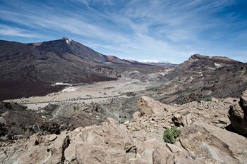 Blich auf die sandige Ebene Llano de Ucanca mit der Felsformation Los Roques – links der Teide, rechts der Guajara | © ©SUNHIKES