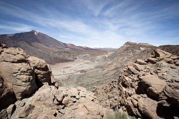 Blick durch die felsige Abbruchkante des Randgebirges der Caldera auf die Ebene von Ucanca – links Teide, rechts Guajara | © ©SUNHIKES