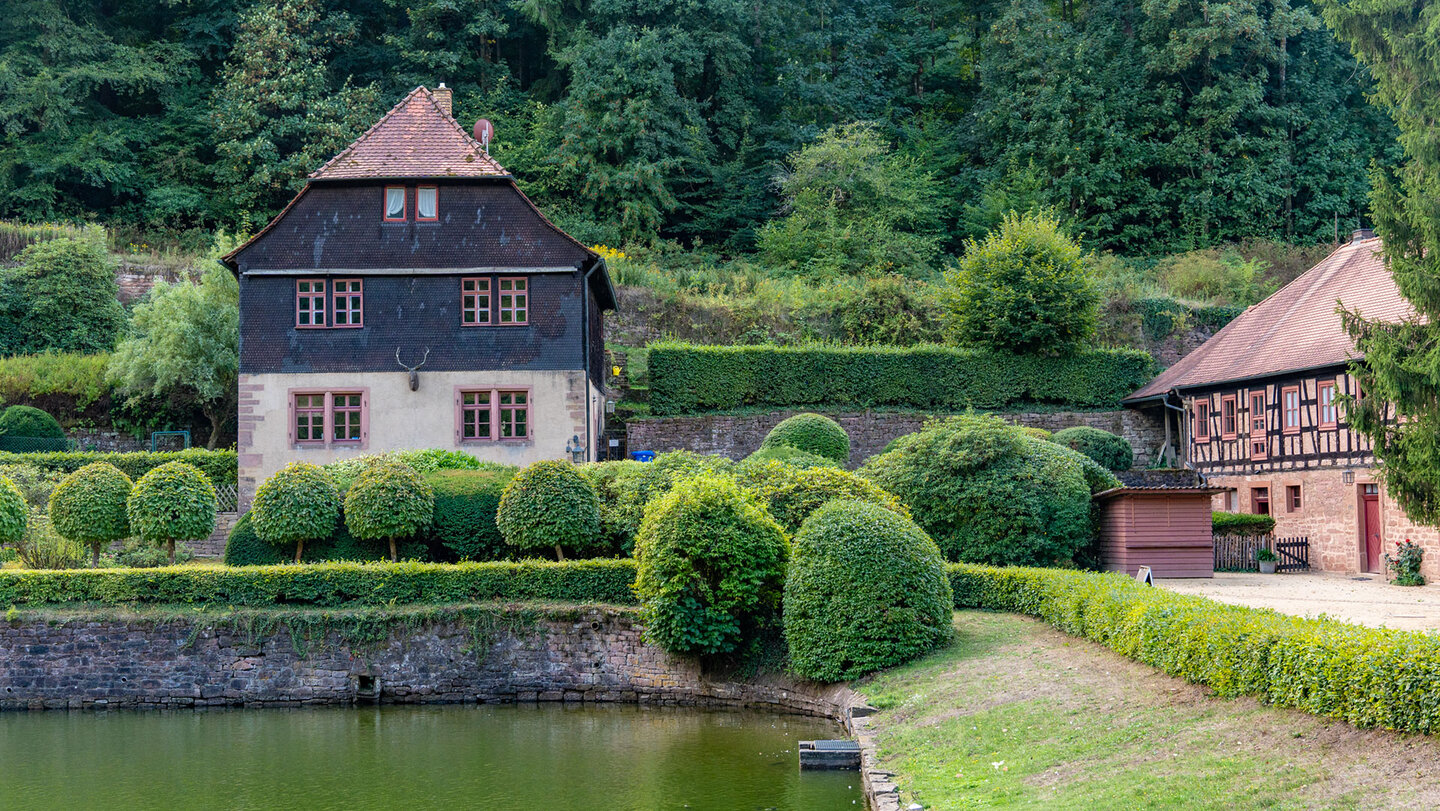 Gartenanlage von Schloss Mespelbrunn mit Formhecken und Teich