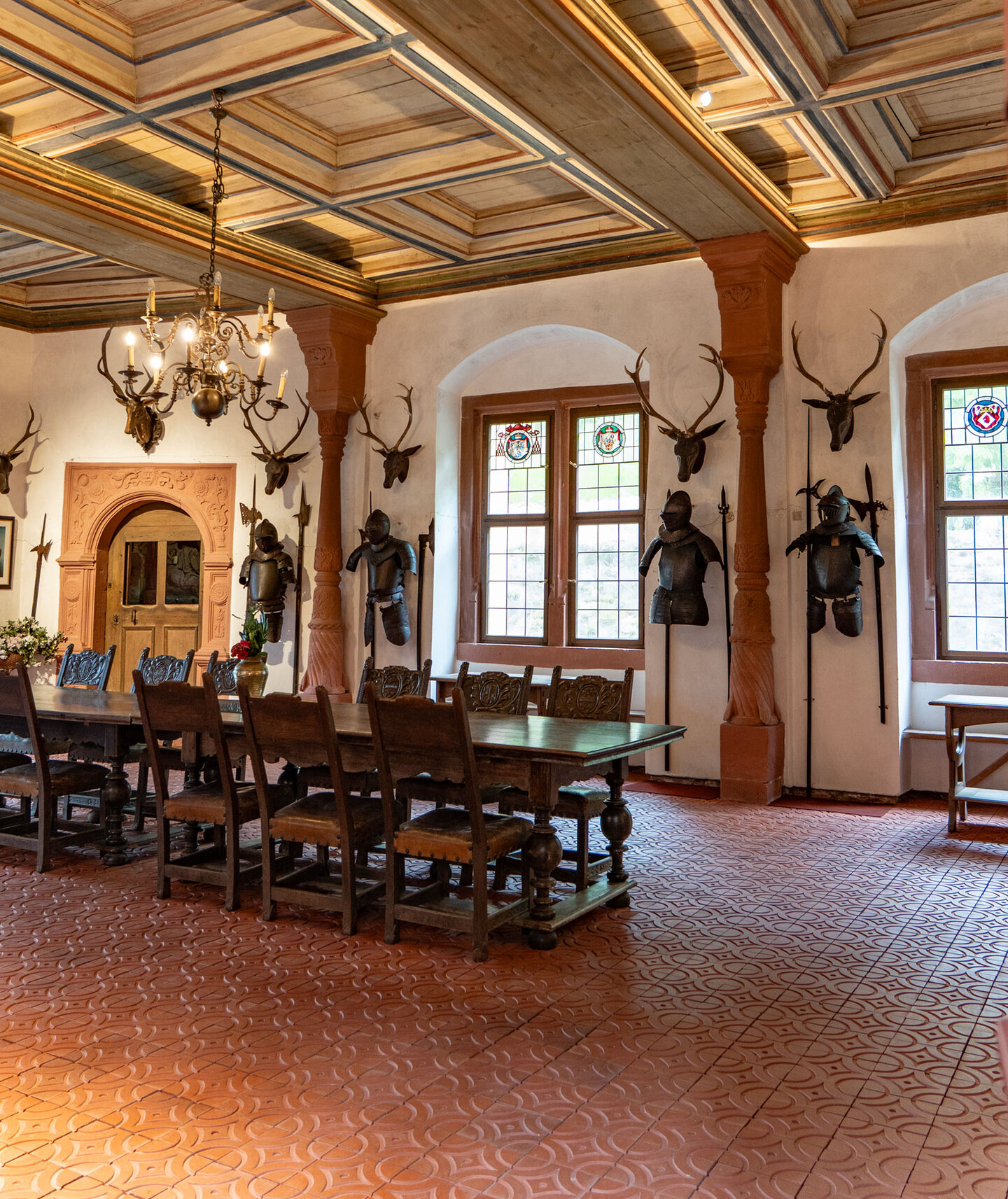 Historischer Saal mit langer Tafel und Rüstungen in Schloss Mespelbrunn
