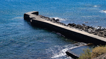 Der Steg und das Meerwasserschwimmbecken von Playa Alojera