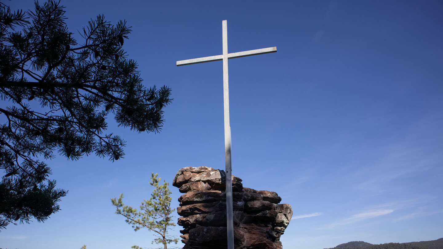 Kreuzelfelsen: Metallkreuz auf dem Buntsandsteinsockel über dem Pfälzerwald