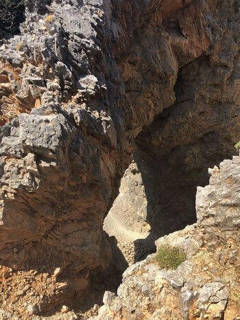 der E4 Wanderpfad führt durch ein beeindruckendes Felstor in Richtung Linoseli-Quelle