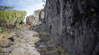 gepflasterter Wanderweg am Fuß einer Basaltwand
