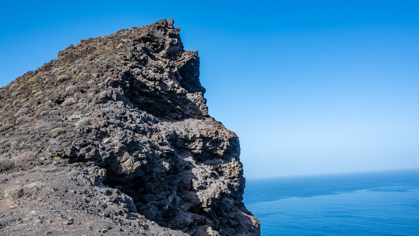 Steil fällt die Felsklippe an der Degollada de El Perchel zum Meer hinab.