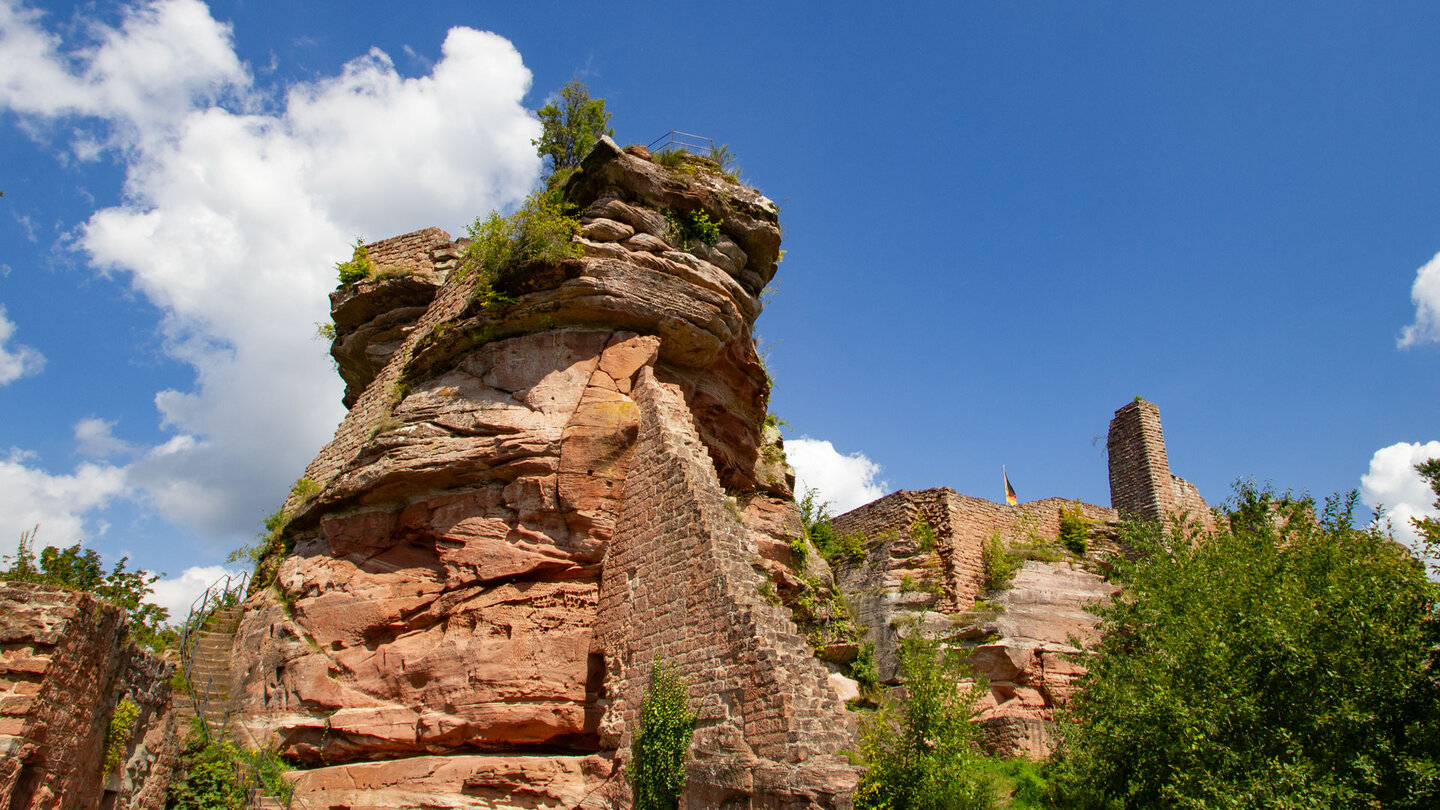 Mächtiger Buntsandsteinfelsen mit Mauerresten und Treppenaufgang der Ruine Tanstein, Burgturm im Hintergrund