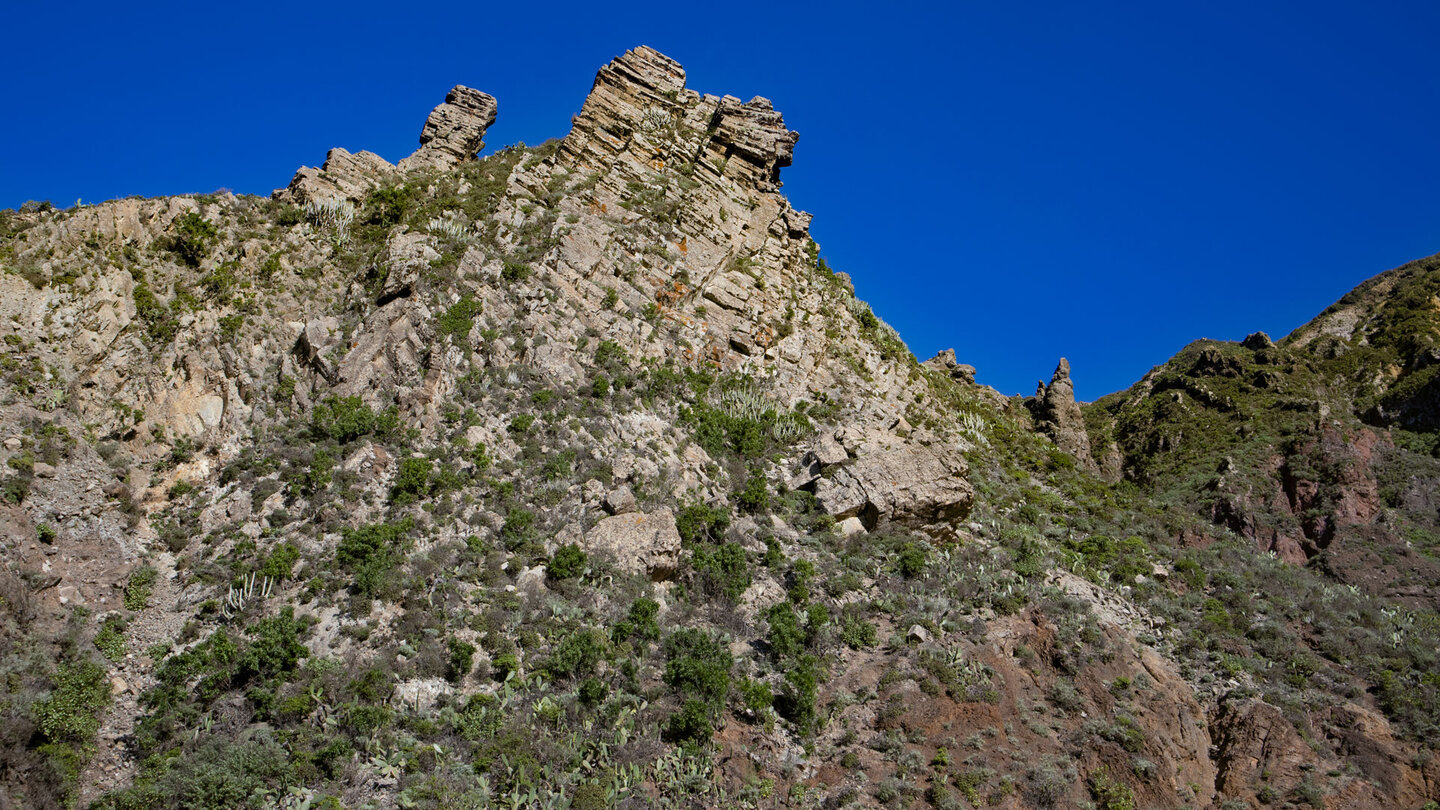 schroffe Basaltformationen an der Bergflanke oberhalb des Ortes El Draguilo