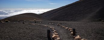 Wanderweg durch Lapillifelder über dem Wolkenmeer