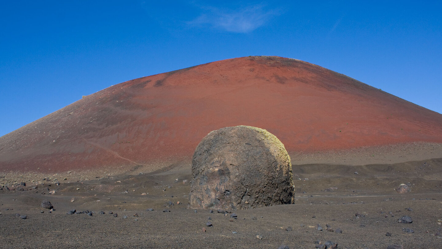 gewaltige Vulkanbombe vor dem rot leuchtenden Montaña Colorada