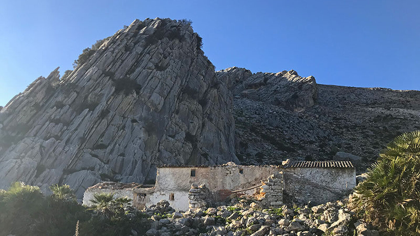 die Ruine einer Finca vor einer hohen Felswand Ruine einer Finca vor einer hohen Felswand