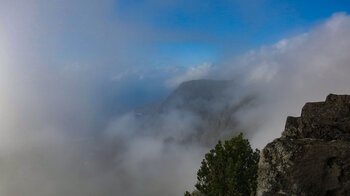 der Ausblick vom Mirador de la Llanía läßt die Steilwände des Risco de Tibataje und die Roques de Salmor zwischen den Wolken erahnen
