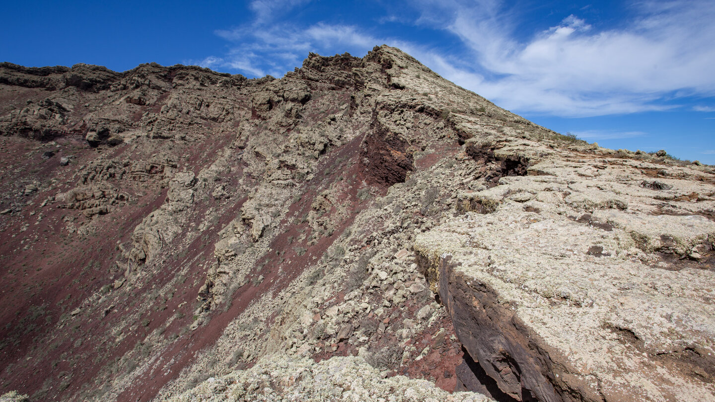 rotes Vulkangestein mit Flechten überwachsen am Kraterrand des Monte Corona