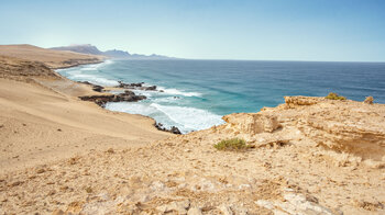 grandioser Ausblick über die Küste der Sandwüste El Jable mit der Silhouette des Jandía-Gebirges