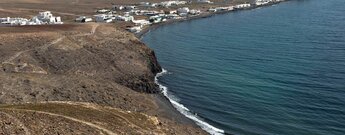 der schwarze Strand Playa de la Arena mit Playa Quemada auf Lanzarote im Hintergrund