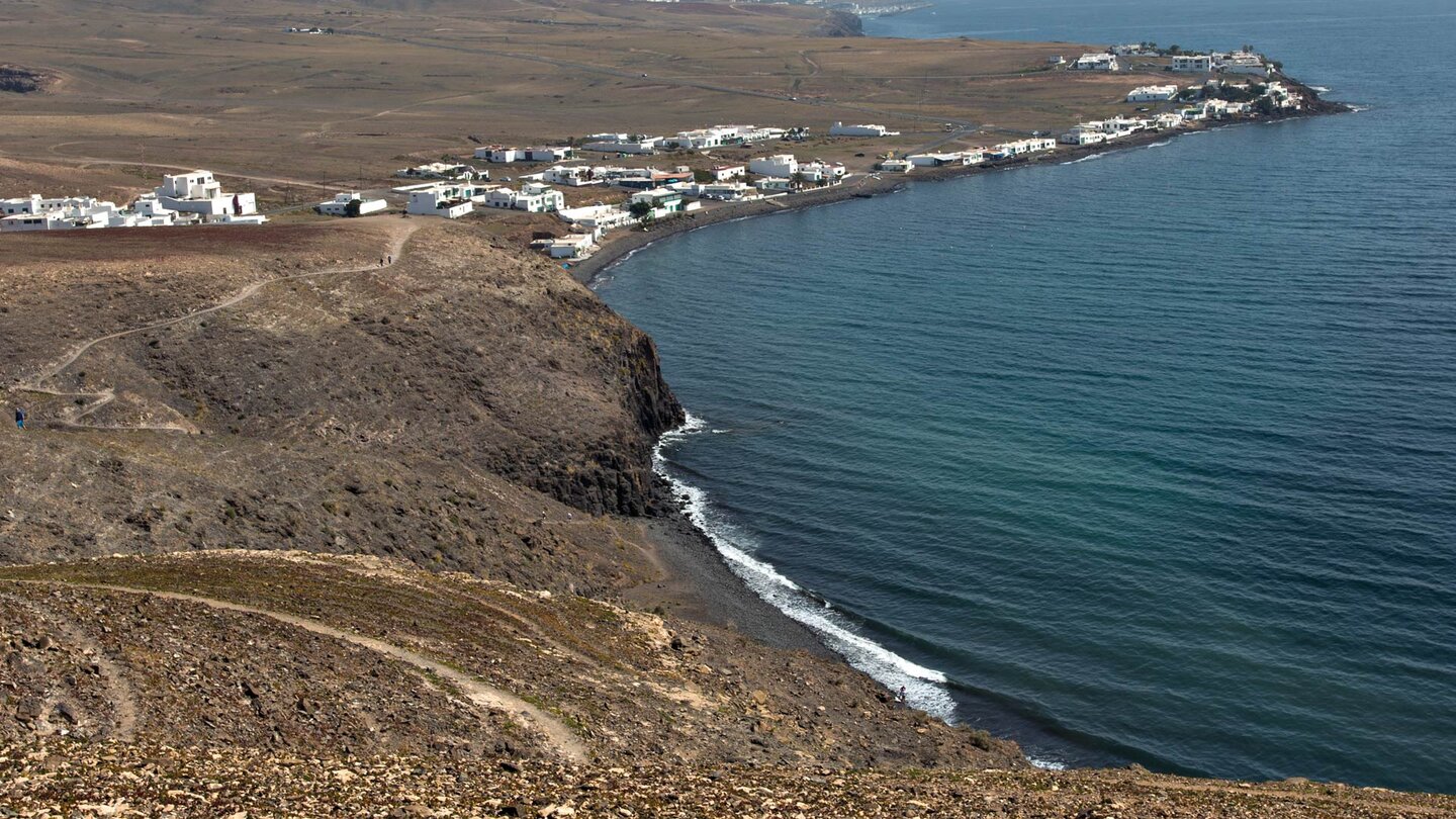 der schwarze Strand Playa de la Arena mit Playa Quemada auf Lanzarote im Hintergrund