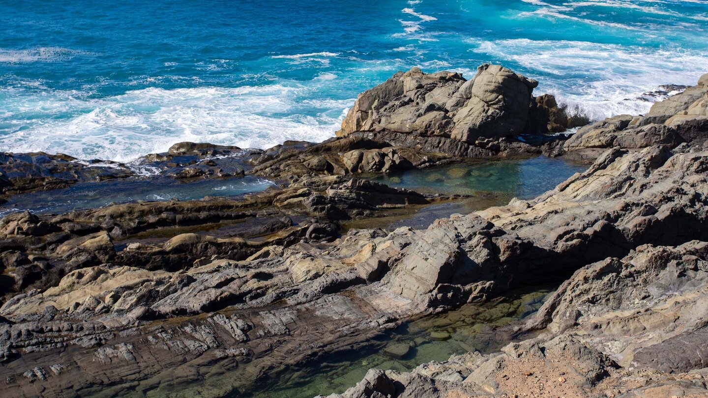 Wasserbecken am Wanderpfad entlang der Abbruchkante der steilen Felsklippen