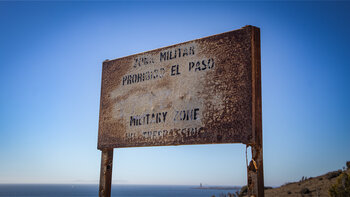 verwitterte Schilder weisen auf das Sperrgebiet hin. Wege und Anfahrtstrecken sind erlaubt