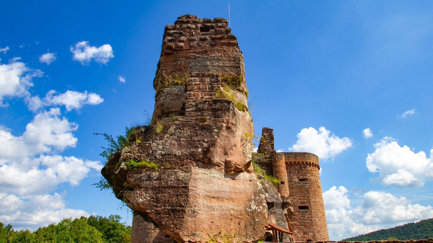 Mächtiger Burgfels der Burg Altdahn mit Geschützturm und rundem Schalenturm, Buntsandstein und Mauerwerk verschmelzen, blauer Himmel mit Wolken