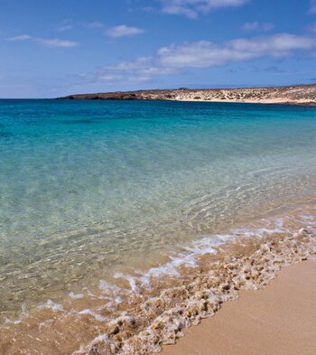 der schöne Sandstrand mit kristallklarem Wasser an der Bahía del Salado