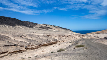 helle Sandflächen und dunkle Gesteinsfelder am Wanderweg