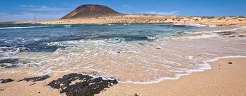 der Strand Playa Francesa mit dem Vulkan Montaña Amarilla im Hintergrund