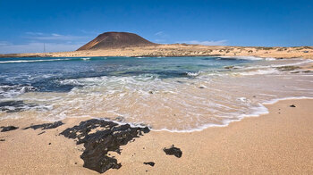 der Strand Playa Francesa mit dem Vulkan Montaña Amarilla im Hintergrund