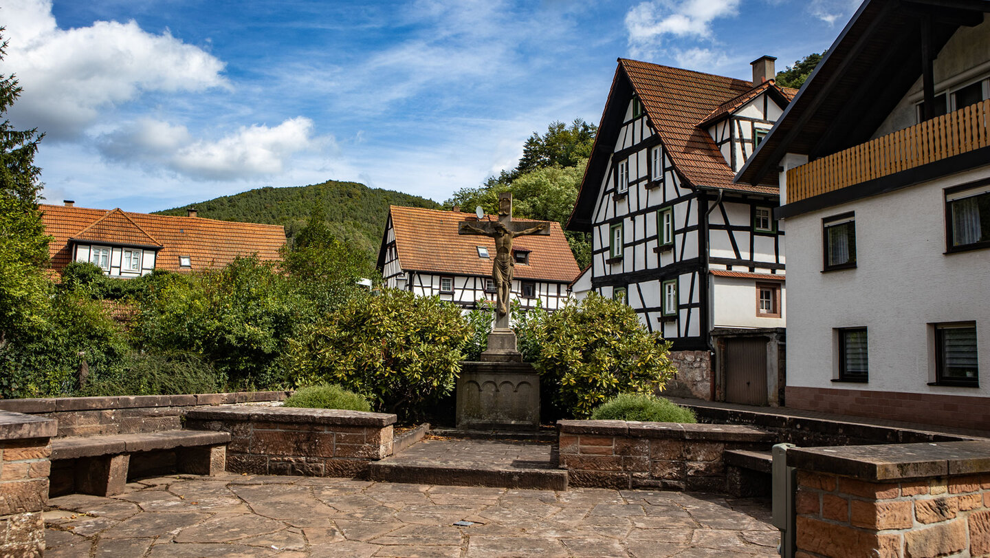 Fachwerkhäuser und Wegkreuz an der Brunnengasse in Erfweiler im Dahner Felsenland