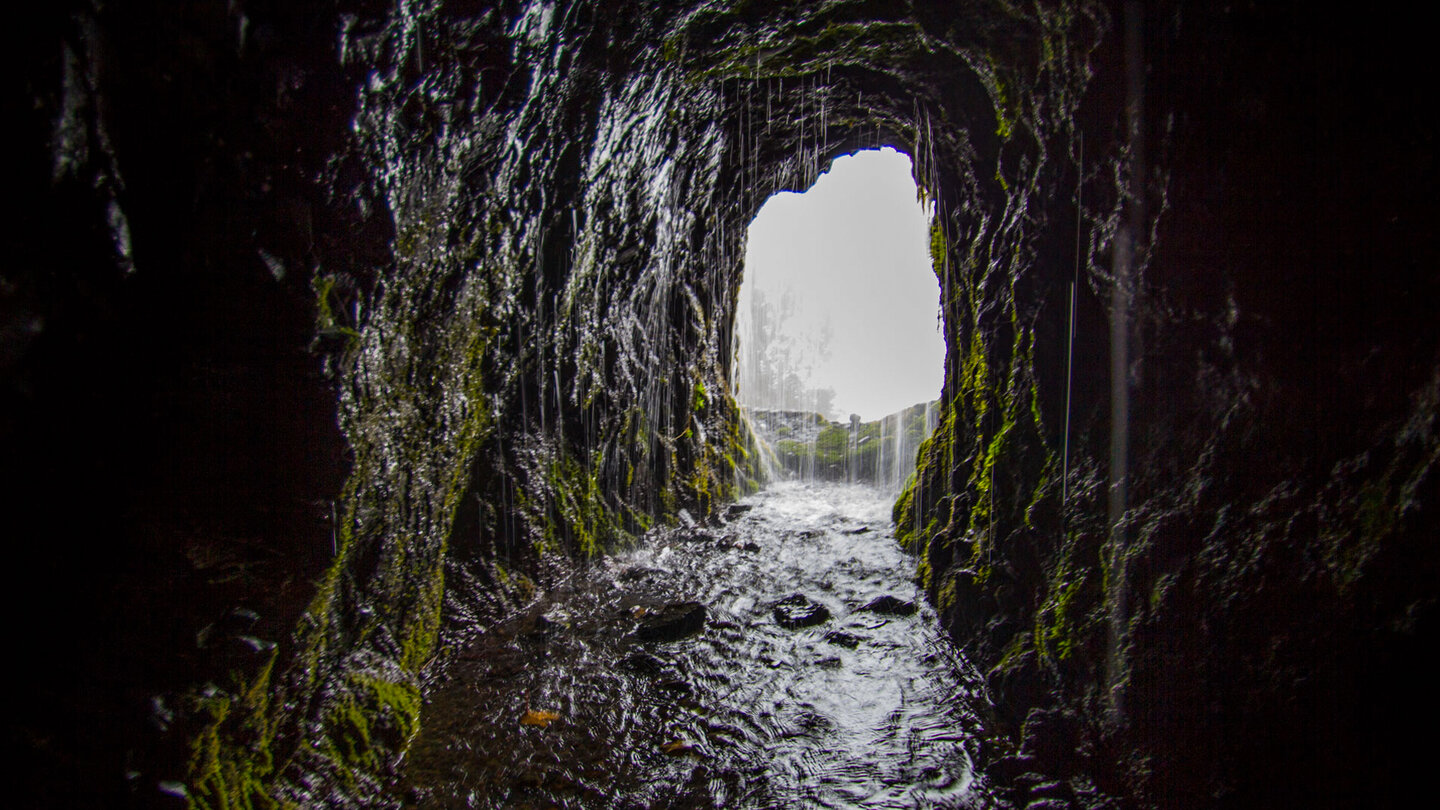 Wasser strömt im letzten Tunnel vor den Marcos Quellen aus dem Fels