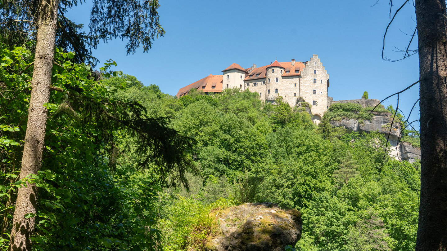 Burg Rabenstein erhebt sich über den Baumkronen im Ailsbachtal
