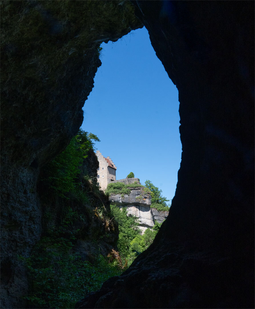 Blick durch eine Felsspalte auf Burg Rabenstein im Ailsbachtal, Fränkische Schweiz.