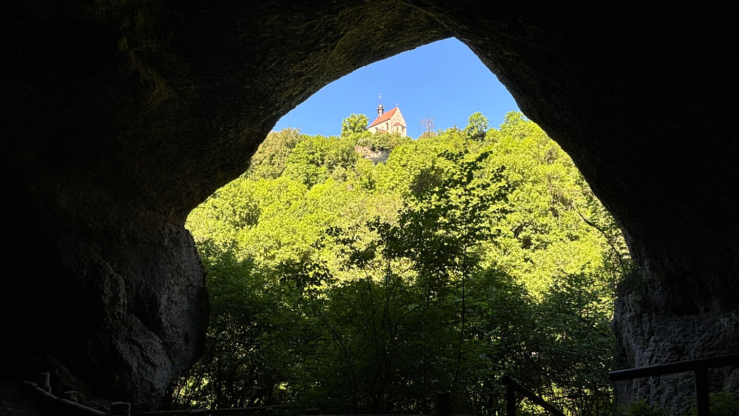 Vom Portal der Ludwigshöhle aus grüßt die Klaussteinkapelle über dem Ailsbachtal.