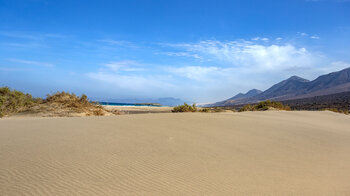Blick über die Sanddünen an der Playa de Cofete mit dem Jandía-Gebirge und der Felseninsel El Islote