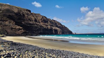 die Playa de Canteria bei Ebbe an den auslaufenden Klippen des Famara-Gebirges auf Lanzarote