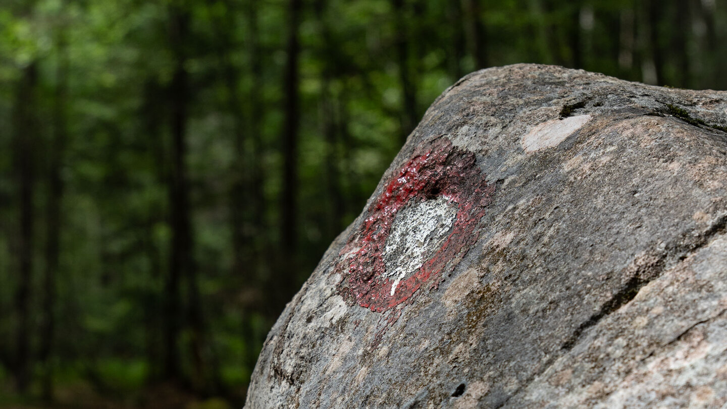 Rot-weiße Knafelc-Wegmarkierung auf einem Felsen im Krnica-Tal