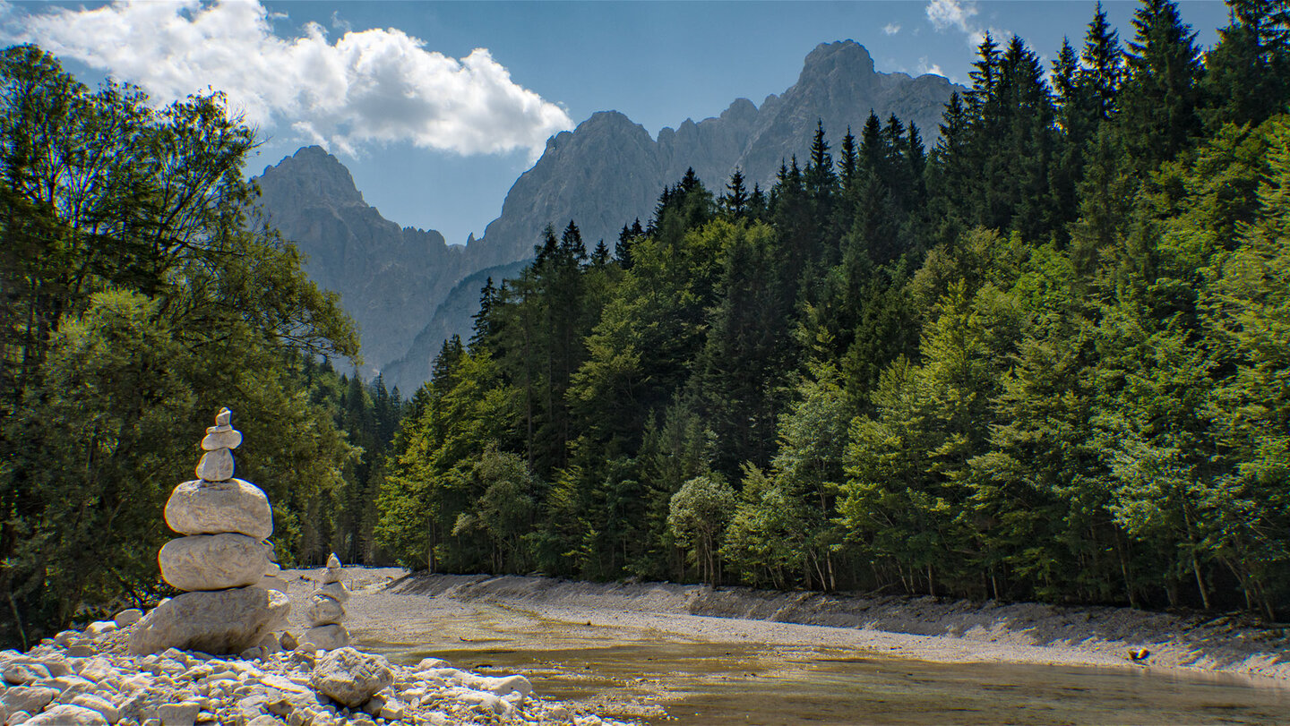 Steinmännchen aus hellen Kalksteinen am Bachbett der Pišnica im Krnica-Tal