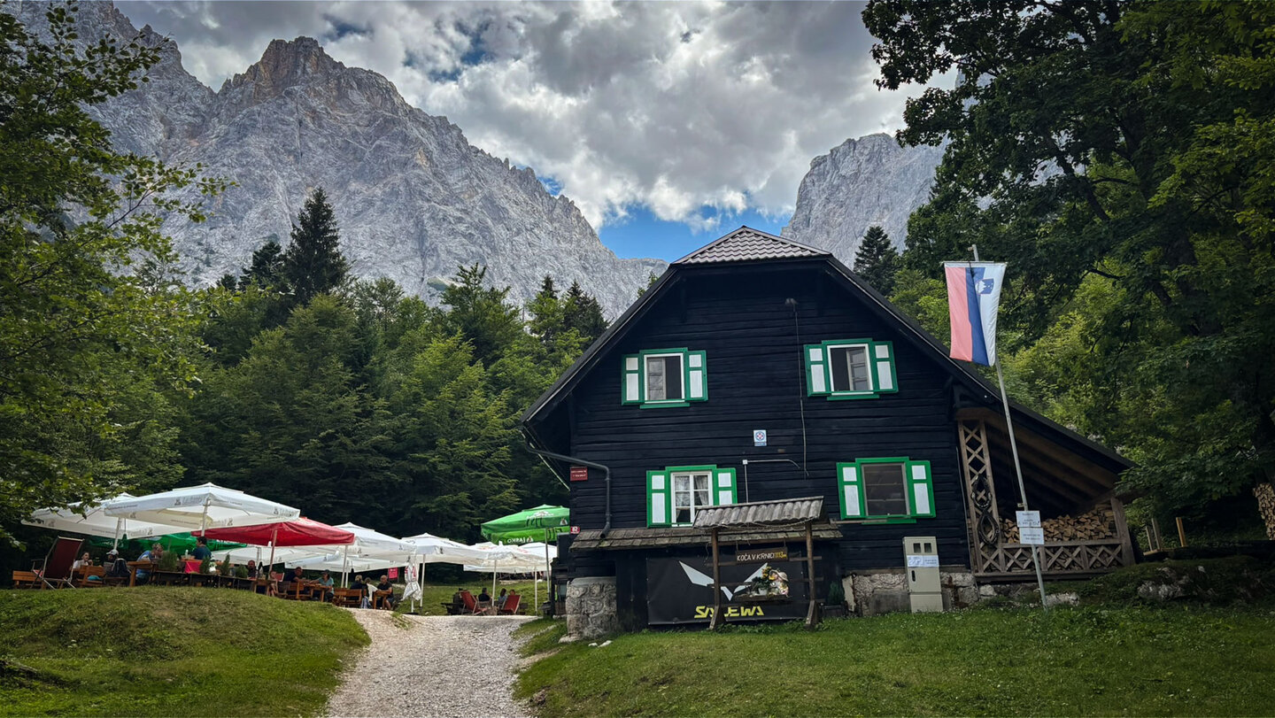 Berghütte Koča v Krnici mit Terrasse vor den Felswänden der Julischen Alpen