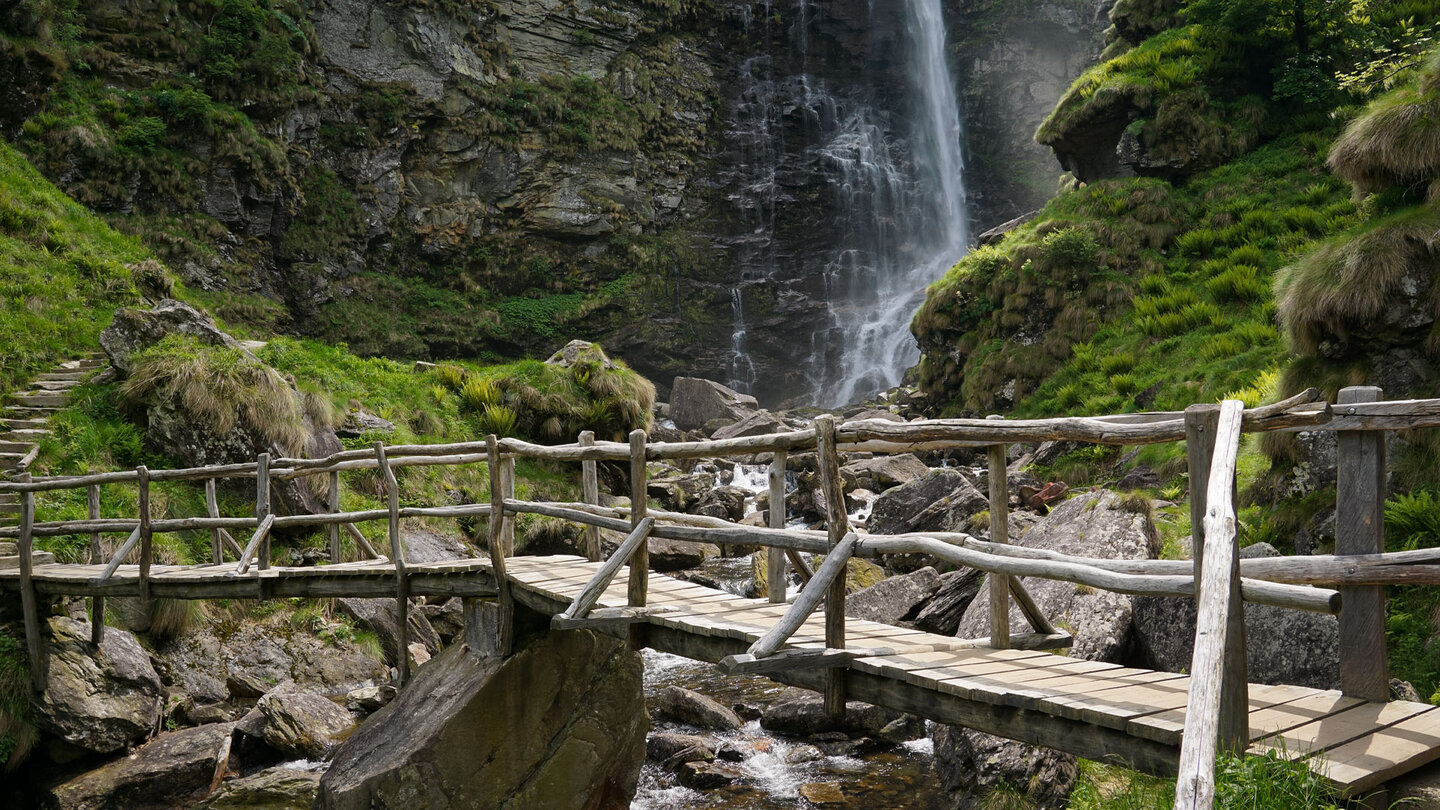 eine Holzbrücke führt am Wasserfall den Riale Carded Holzbrücke über den Riale Carded am Wasserfall