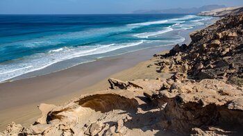 Blick auf den Sandstrand Playa de Barlovento über ausgewaschene Felsformationen