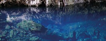 die Albinokrebse wirken wie weiße Punkte im azurblauen Salzwassersee des Jameos del Agua auf Lanzarote