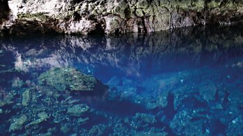 die Albinokrebse wirken wie weiße Punkte im azurblauen Salzwassersee des Jameos del Agua auf Lanzarote