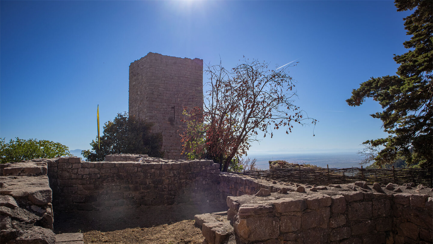 Bergfried der Burg Weckmund bei den Drei Egsen im Gegenlicht, rechts Flechtzaun und Blick in die Rheinebene