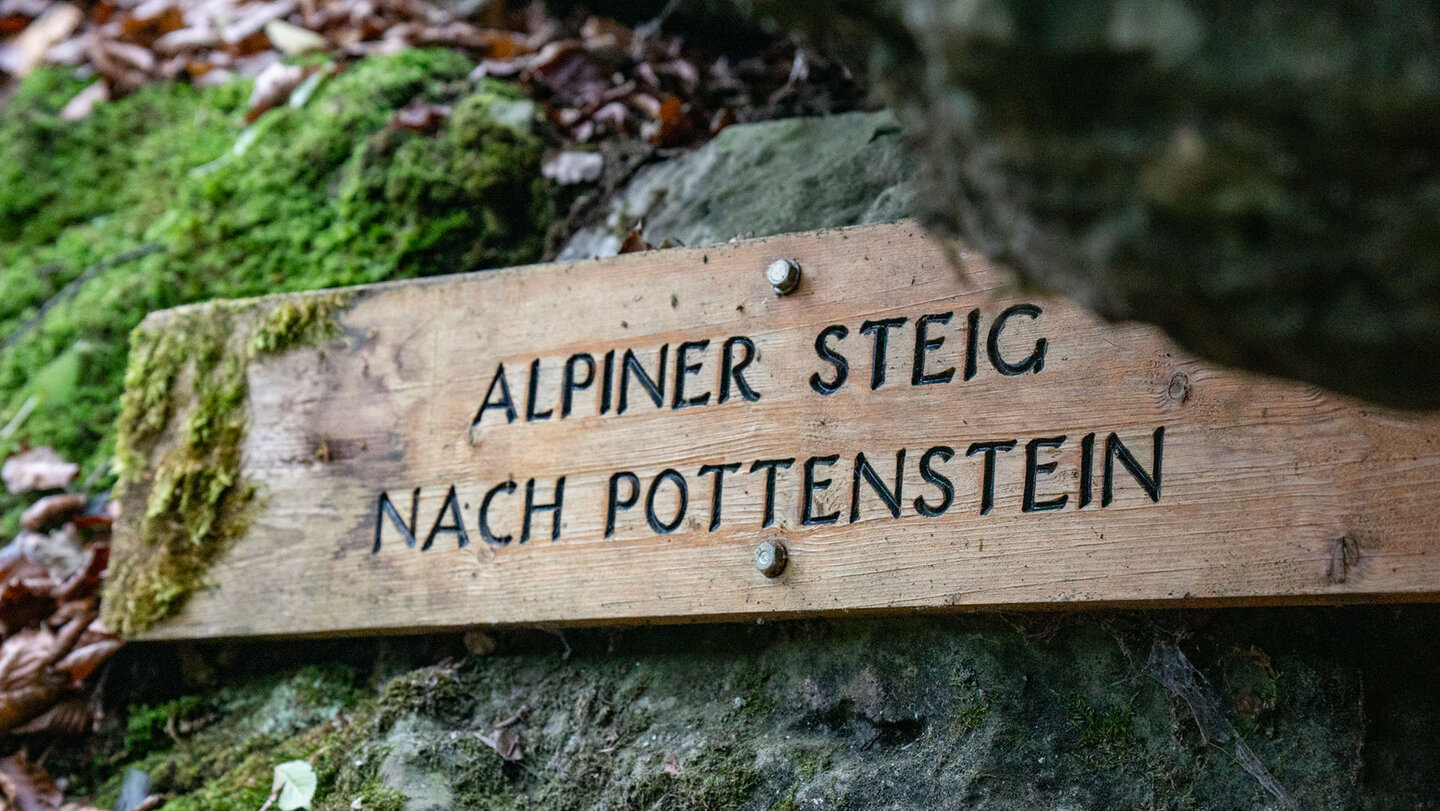 Der hölzerne Wegweiser zeigt den Einstieg zum Alpinen Steig bei Pottenstein.