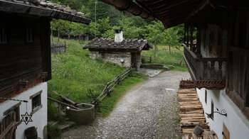 Weg entlang alter Hofgebäude im Markus Wasmeier Freilichtmuseum
