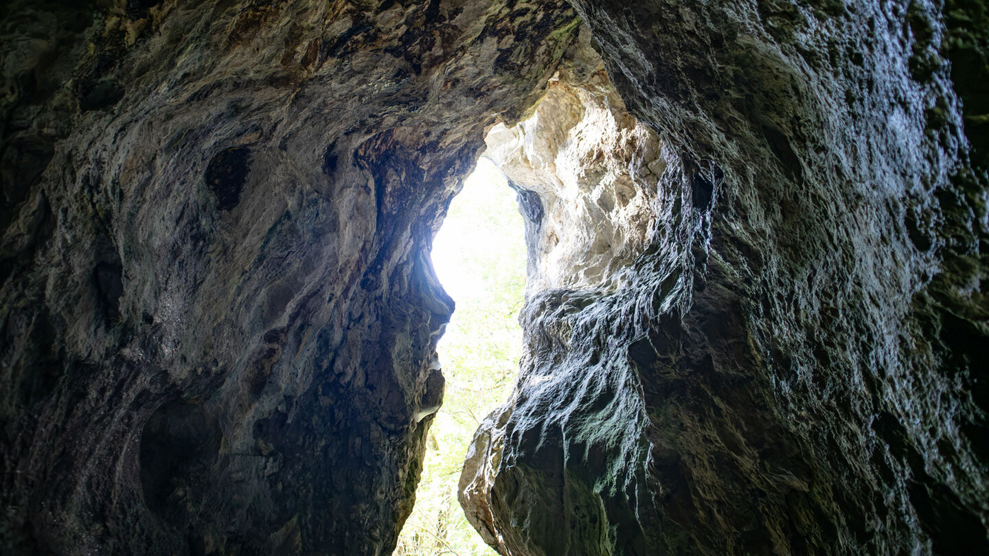 Blick aus dem Inneren der Schwarzwagfelshöhle durch einen schmalen Felsspalt nach draußen