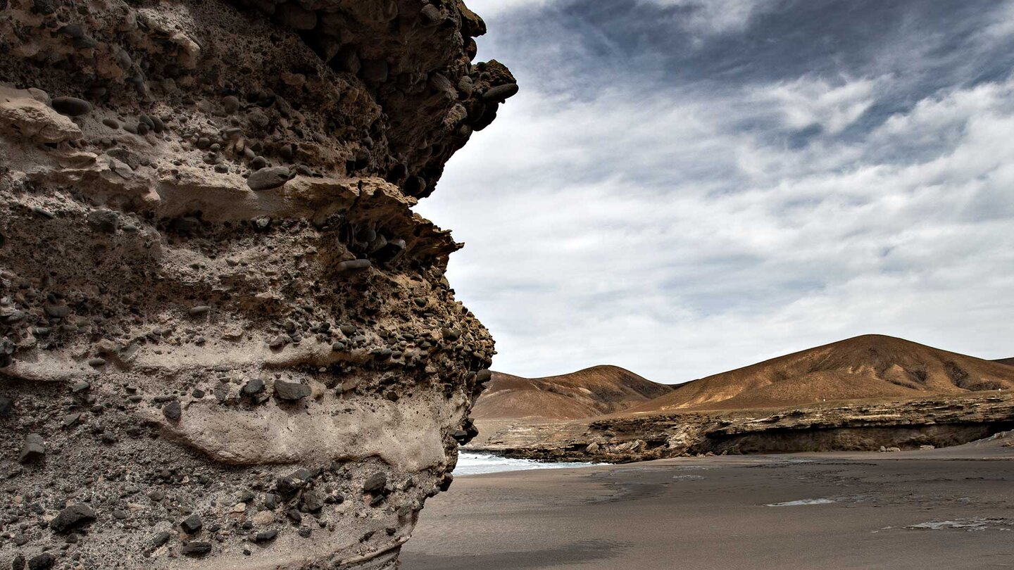 Gesteinsschichtungen aus Sedimentablagerungen an der Playa de la Solapa