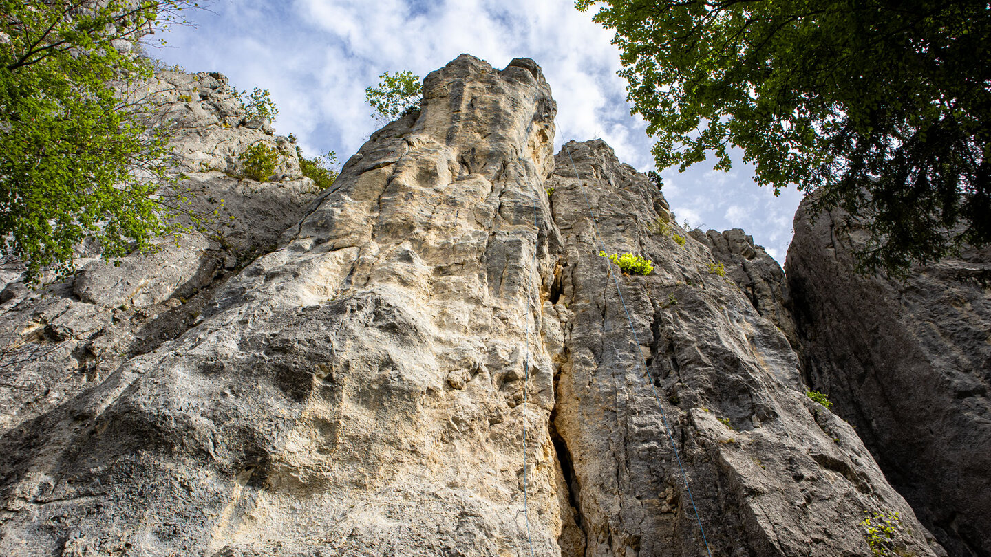 Froschperspektive auf die Kalksteinwand der Hausener Zinnen bei Hausen im Tal – steile Felsflucht mit Kletterrouten unter blauem Himmel
