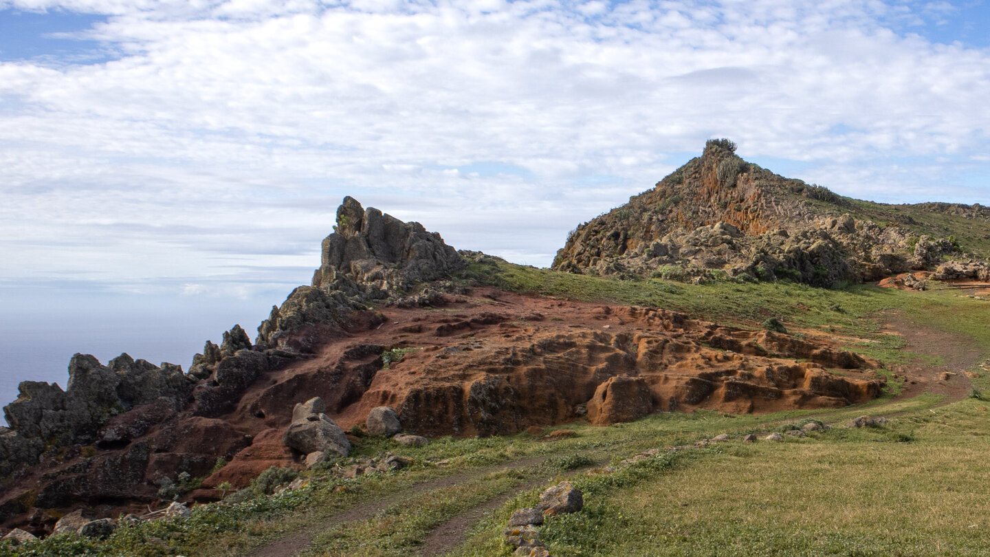 Blick zum Roque del Andén über eine rostbraune, erodierte Felsfläche