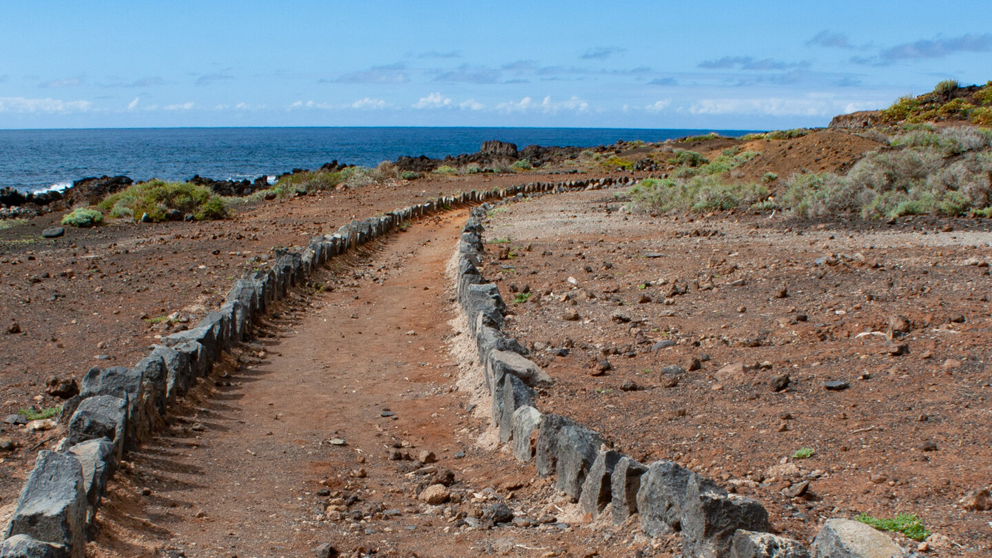 mit Steinen eingefasster Wanderweg an der Küste der Tiefebene Teno Bajo